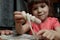 A little girl is preparing a treat for Halloween- mummy sausages. Selective focus. Cooking workshops for children