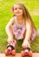 Little girl preschool beginner sitting in the grass with her roller skates, in a grass background