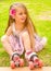 Little girl preschool beginner sitting in the grass with her roller skates, in a grass background