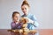 Little girl preschooler and her elder sister playing together with wooden blocks game toy