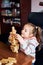 Little girl preschooler playing with wooden blocks toy building a house