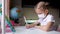 Little girl in a protective mask at distance home schooling, quarantine