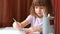 Little girl puts colored pencils in jar