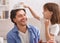 Little girl putting crown on her laughing father head