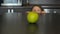 Little girl reaching for a green apple on the table