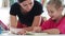 Little girl reading with help of teacher