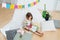 Little girl reading next to a hut with stay at home flag garland across