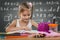 Little girl reading in school, written job behind the plate