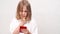 Little girl reads the message and talking on the phone at the white wall.