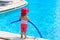 Little girl ready to jump into the pool with noodle