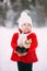 Little girl in red coat with a teddy bear having fun on winter day. girl playing in the snow