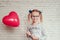 Little girl with red heart shaped baloon, Valentine's day background