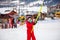 Little girl in red overall using button lift in ski resort in Bakuriani, Georgia