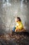 Little girl with red persian cat in the forest. Soft natural light. Cat is looking forward. Girl lay down her hand on cat