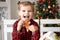 little girl in red pyjama holding decorated Christmas gingerbread men cookie