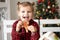 little girl in red pyjama holding decorated Christmas gingerbread men cookie