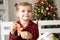 little girl in red pyjama holding decorated Christmas gingerbread men cookie