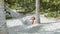 Little girl relaxing at cozy hammock in tropical garden