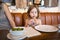 Little girl in restaurant looking olive in hand