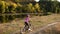 A little girl rides a Bicycle in a protective helmet near river in nature