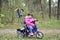 Little girl rides a bicycle in the woods.