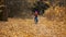 A little girl rides a bike in the autumn Park and falls