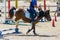Little Girl that rides a brown Pony and Jumps the obstacle during Pony Game competition at the Equestrian School