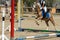Little Girl that rides a brown Pony and Jumps the obstacle during Pony Game competition at the Equestrian School