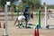 Little Girl that rides a white Pony and Jumps the obstacle during Pony Game competition at the Equestrian School