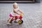 A little girl is riding a balance bike