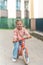 Little girl riding balance bike in the courtyard of the residence in Prague, Europe