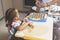 Little girl rolls out the dough, while her mother sculpts the dumplings for the holiday