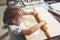 Little girl rolls out the dough with a large rolling pin for making homemade cookies