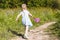 Little girl is runnig on forest path to catch butterfly