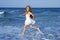 Little girl running beach in blue sea