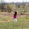 A a little girl running on the grass with her back to the camera