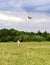 A little girl running on green grass after the bright flying kite