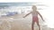 Little girl runs through surf