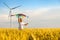 Little girl runs in a wheat field with a kite