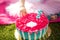 Little girl`s hand tastes a beautiful pink flower shaped cake