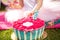 Little girl`s hand tastes a beautiful pink flower-shaped cake.