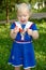 Little girl in sailor blue dress walk in the park.