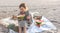 Little girl on the sandy seashore at a picnic with fruits.