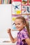 Little girl at the school sitting in the front desk