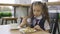 Little girl in school uniform having lunch in the school cafeteria.