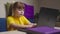 Little girl schooler does homework on laptop at desk in room