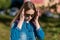 Little girl schoolgirl, teenager summer outdoor. Sunglasses and denim jacket. Corrects hair with hands.