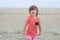Little girl screaming in big landscape environment. Child emotionally saying loudly, singing a song with expression