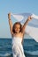 Little girl on sea shore playing with a kerchief in the wind