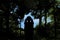 A little girl is seen in silhouette as she arrives at an opening in the forest